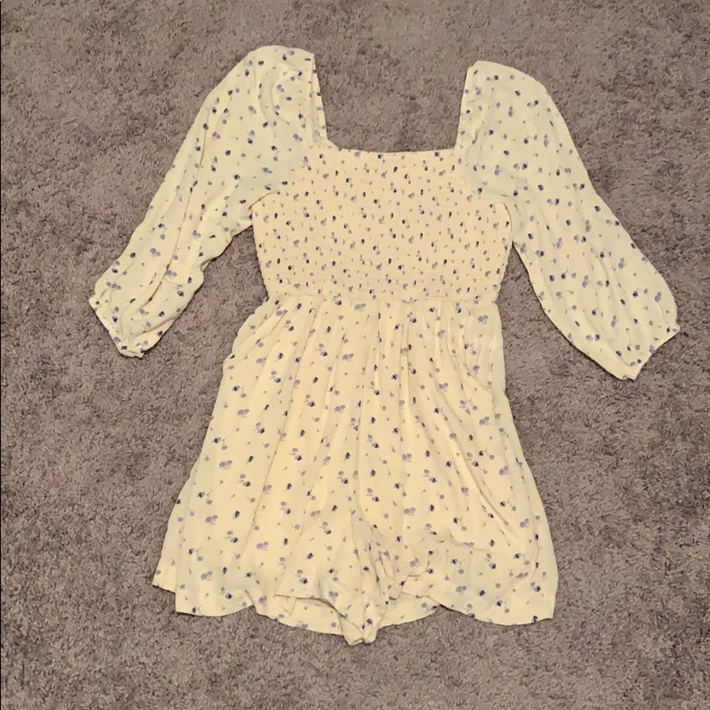 Off the shoulder creme floral romper with pockets.